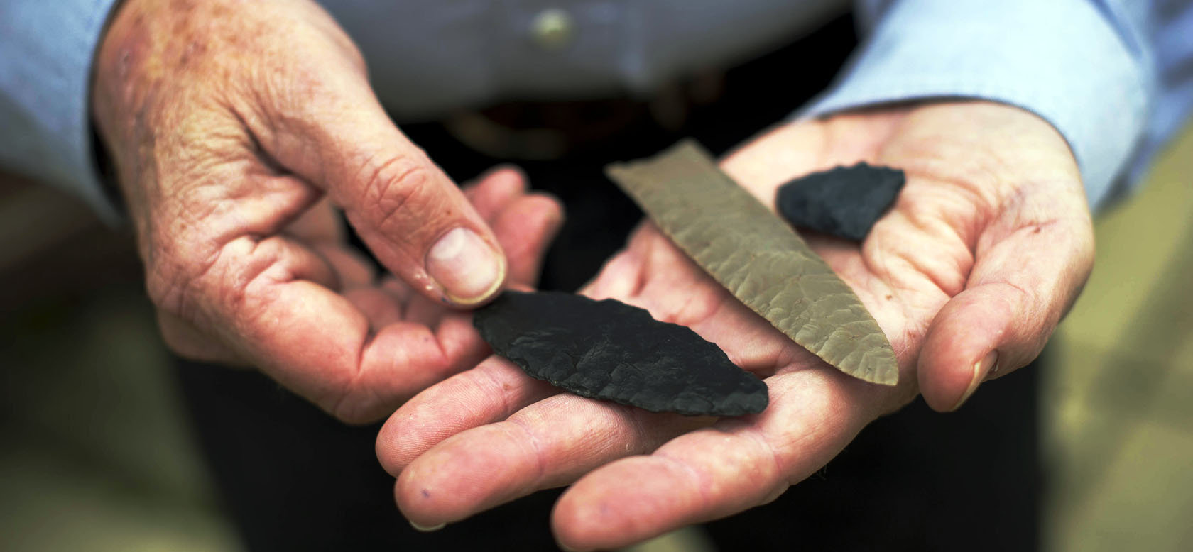 Clovis-made stone tools in the hands of Bruce Bradley, co-author of Across Atlantic Ice: The Origin of America’s Clovis Culture. (Photo by Jim Wileman)