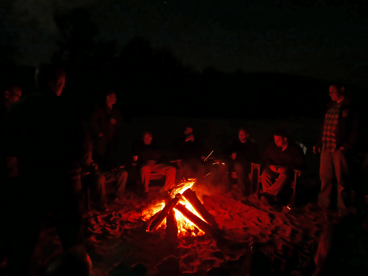 Employees gathering around the campfire after the day's meeting